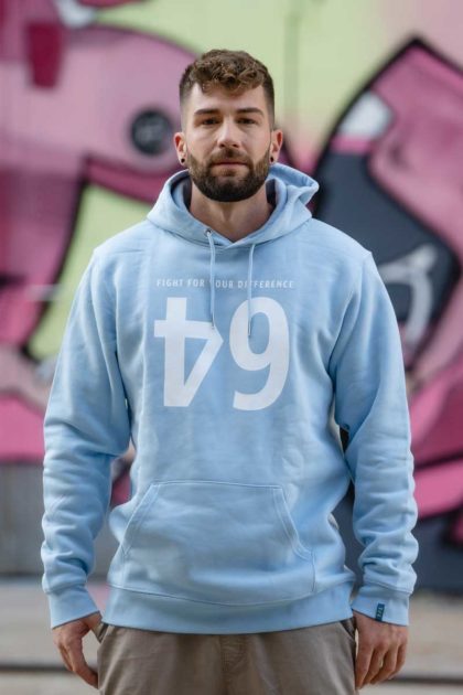 Un homme portant le hoodie bleu ciel avec le logo "64"
