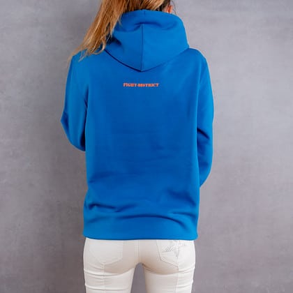 Image de dos d'une femme portant un hoodie bleu clair au logo orange de la collection flag