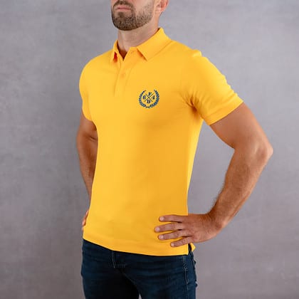 Image de face d'un homme portant un polo jaune au logo bleu de la collection Laurier
