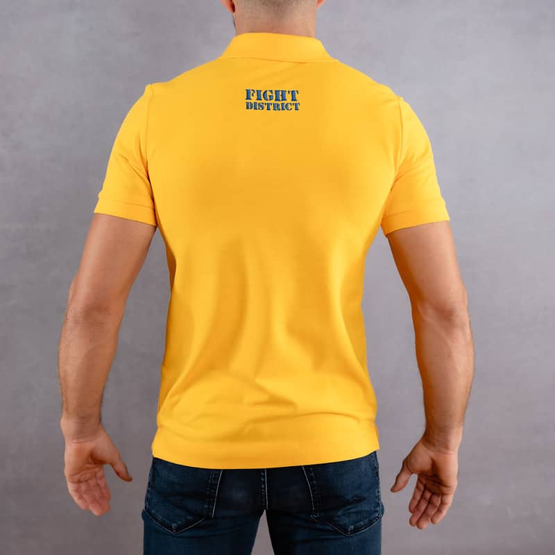 Image de dos d'un homme portant un polo jaune au logo bleu de la collection Laurier