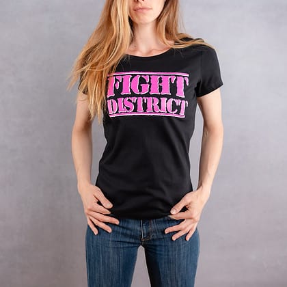 Image de face d'une femme portant un T-Shirt noir slim au logo rose de la collection The Original