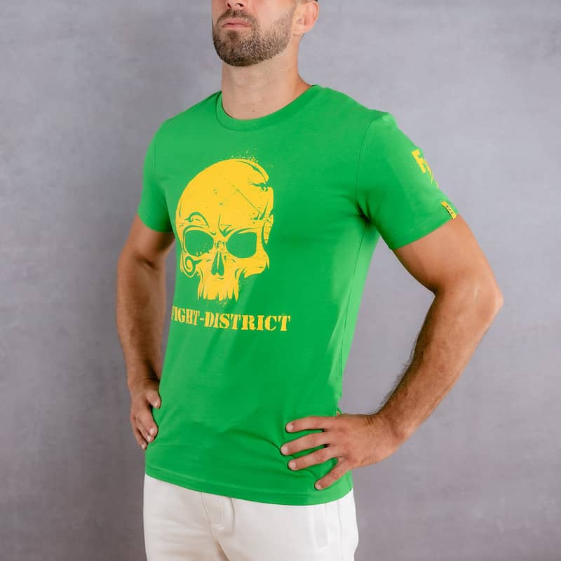 Image de face d'un homme portant un T-Shirt vert au logo jaune de la collection Cabal Skull
