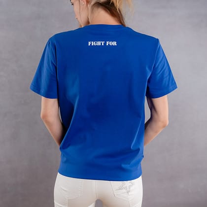 Photo de dos d'une femme portant un T-shirt bleu roi au logo blanc de la collection The Original