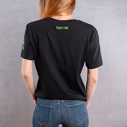 Image de dos d'une femme portant un T-Shirt noir au logo vert de la collection Cabal Skull
