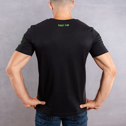 Image de dos d'un homme portant un T-Shirt noir au logo vert de la collection Cabal Skull