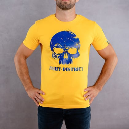 Image de face d'un homme portant un T-Shirt jaune au logo bleu de la collection Cabal Skull