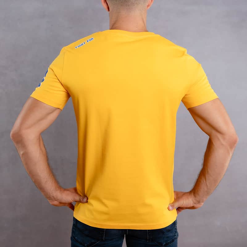 Image de dos d'un homme portant un T-Shirt jaune au logo bleu de la collection College