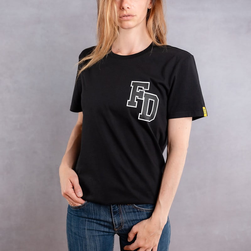 Image de face d'une femme portant un T-Shirt noir au logo noir de la collection Arrow