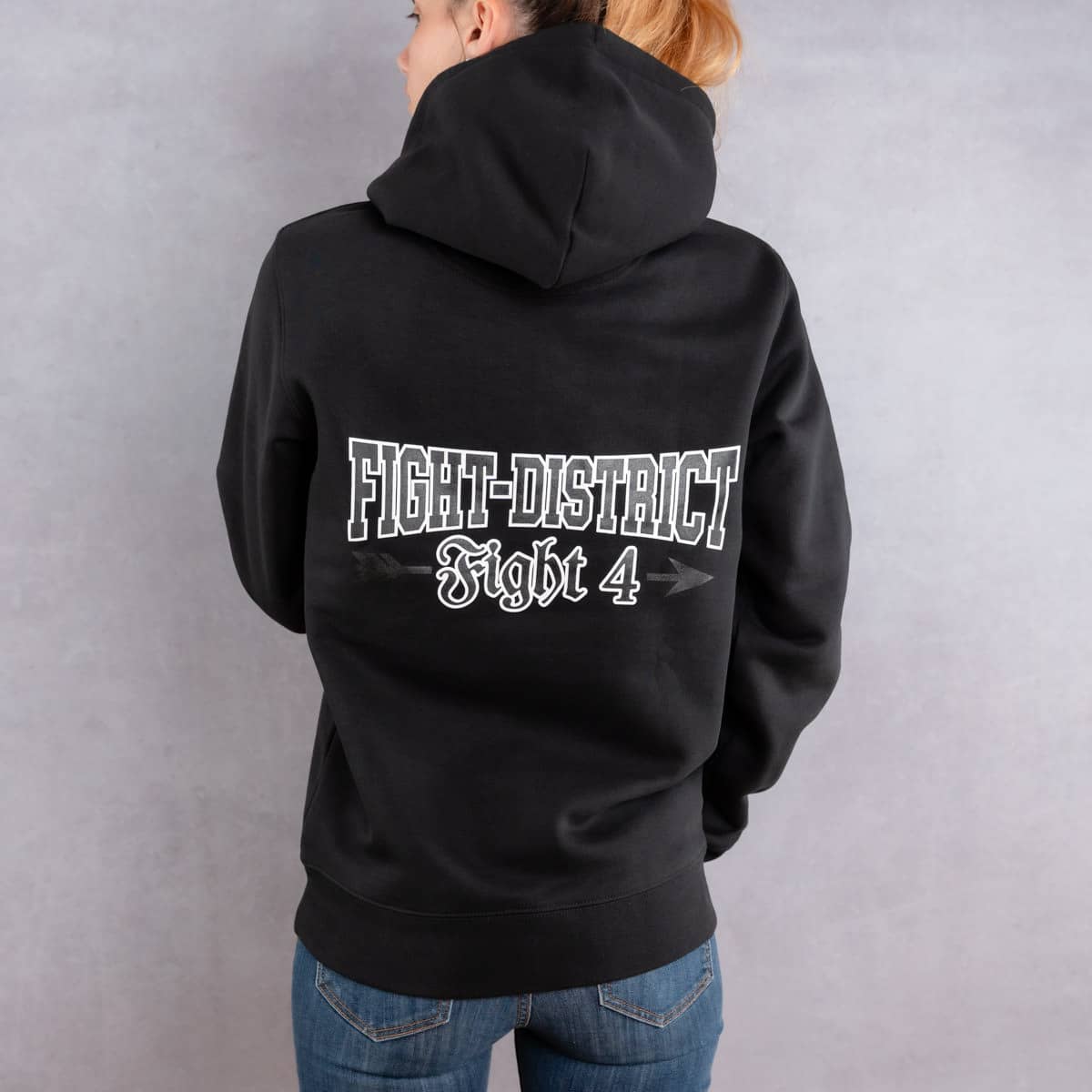 Image de dos d'une femme portant un hoodie noir au logo noir de la collection Arrow