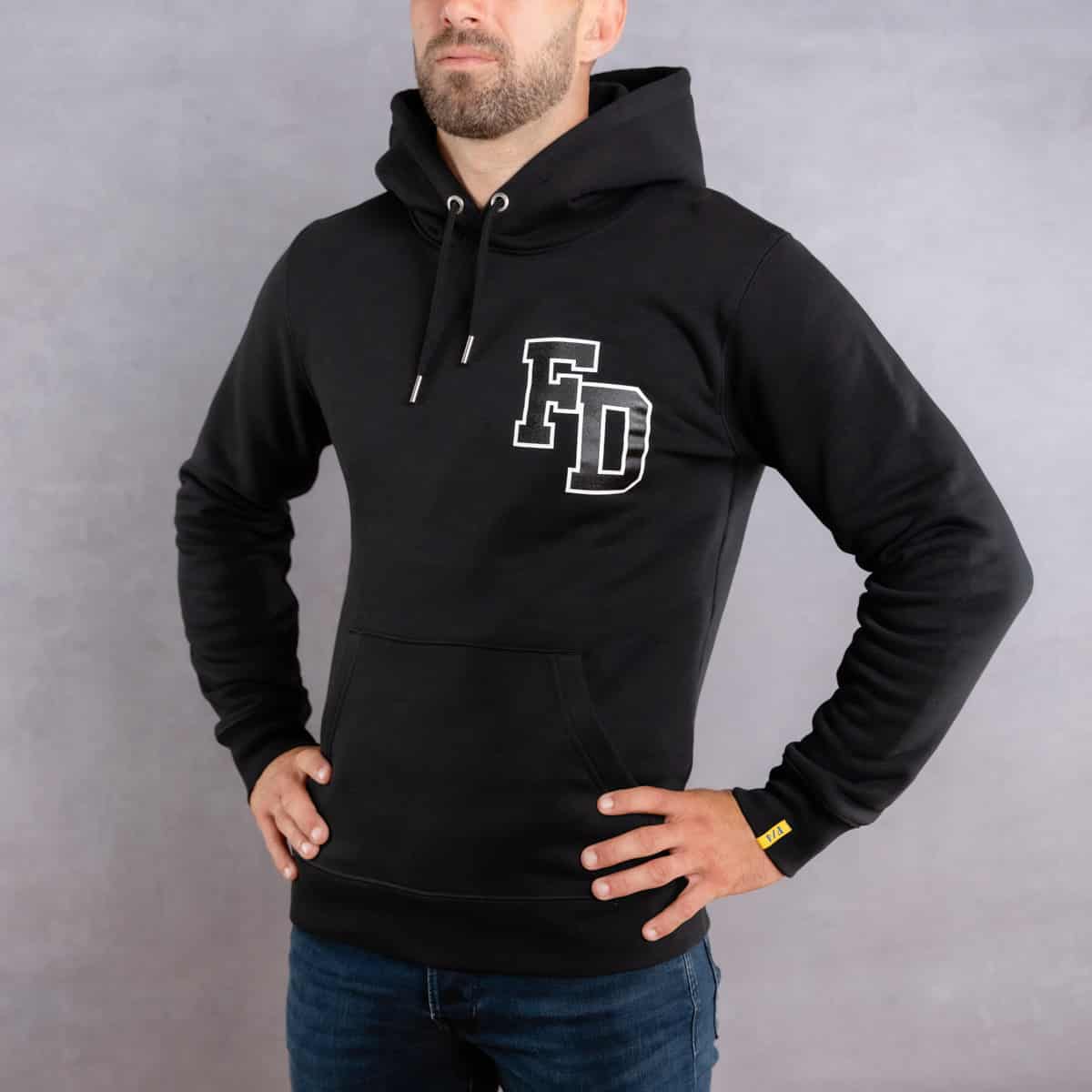 Image de face d'un homme portant un hoodie noir au logo noir de la collection arrow