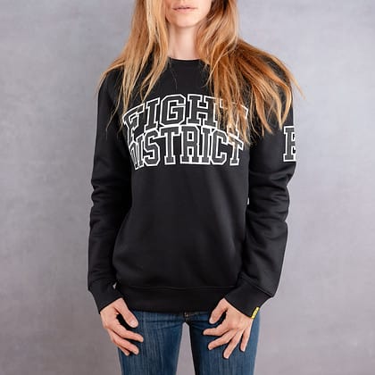 Image de face d'une femme portant un pull noir au logo noir de la collection College