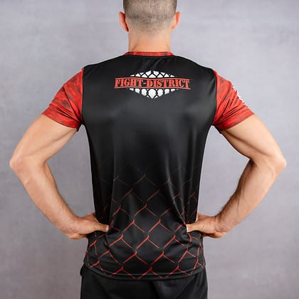 T-shirt avec un col rond avec des camouflages rouge et noir sur les manches porté par un homme de dos avec le logo de la salle de sport fight-district