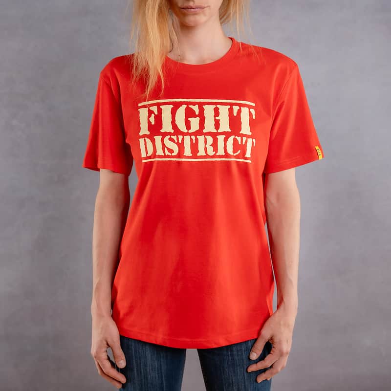 Image de face d'une femme portant un T-Shirt rouge au logo blanc de la collection The Original