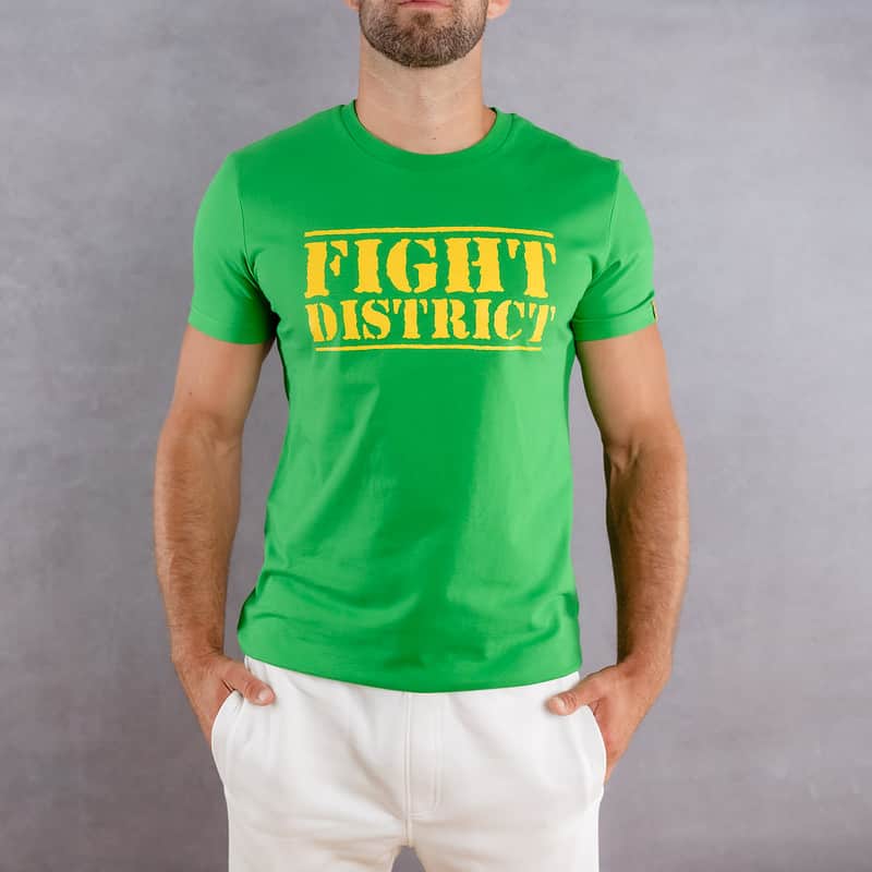 Image de face d'un homme portant un T-Shirt vert au logo jaune de la collection The Original