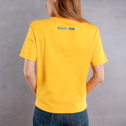 Photo de dos d'une femme portant un T-shirt jaune au logo bleu de la collection The Original