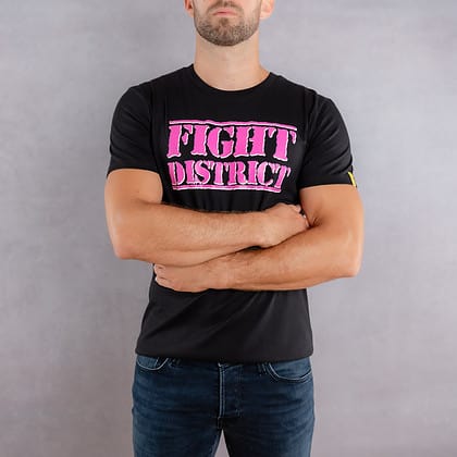 Image de face d'un homme portant un T-Shirt noir au logo rose de la collection The Original