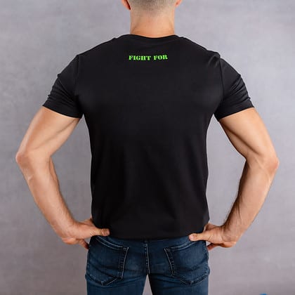 Image de dos d'un homme portant un T-Shirt noir au logo vert de la collection The Original