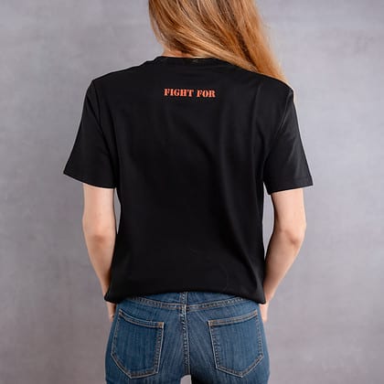 Photo de dos d'une femme portant un T-shirt noir au logo rouge de la collection The Original