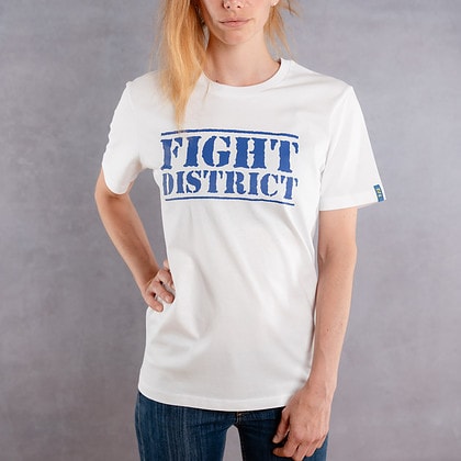 Photo de face d'une femme portant un T-shirt blanc au logo bleu de la collection The Original