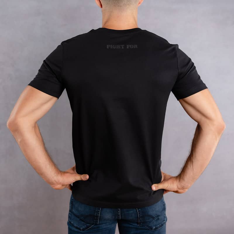 Image de dos d'un homme portant un T-Shirt noir au logo noir de la collection The Original