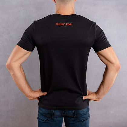 Image de dos d'un homme portant un T-Shirt noir au logo rouge de la collection The Original
