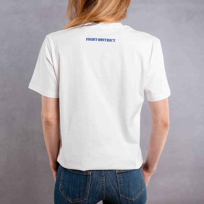 Photo de dos d'une femme portant un T-shirt blanc au logo bleu de la collection Flag