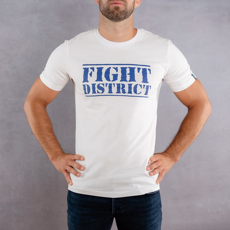 Image de face d'un homme portant un T-Shirt blanc au logo bleu de la collection The Original