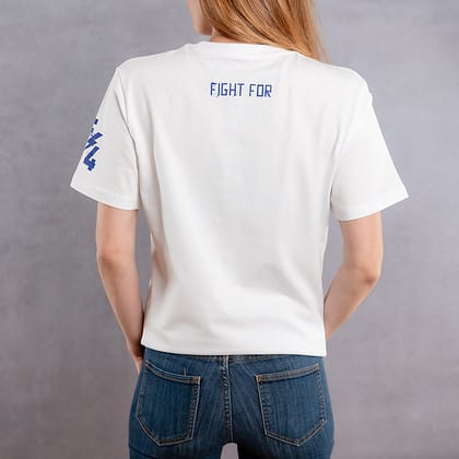 Image de dos d'une femme portant un T-Shirt blanc au logo bleu de la collection Cabal Skull