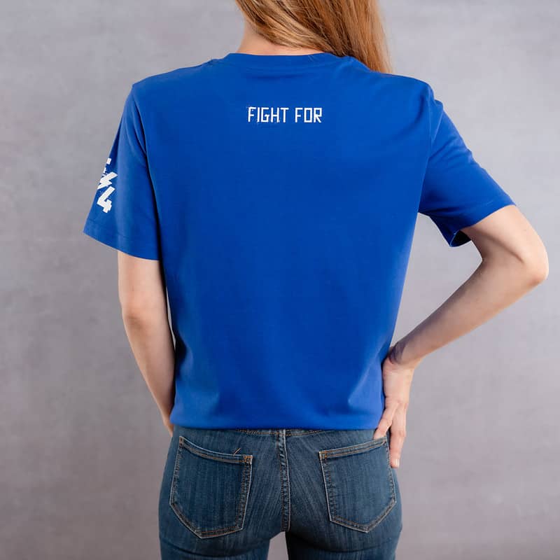 Image de dos d'une femme portant un T-Shirt bleu roi au logo blanc de la collection Cabal Skull