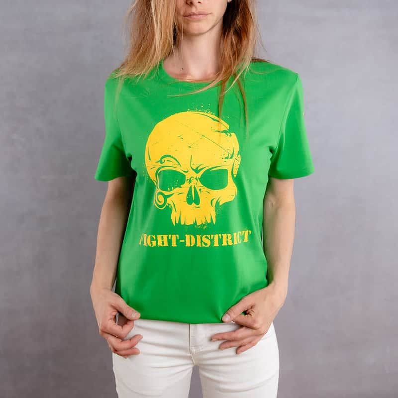 Image de face d'une femme portant un T-Shirt vert au logo jaune de la collection Cabal Skull